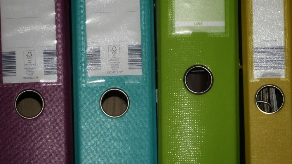 Rows of colored binders on a shelf